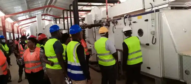 Dei Biopharm Vaccines Plant engineer Henry Nangeri shows a team of MPs part of installed pharmaceutical equipment